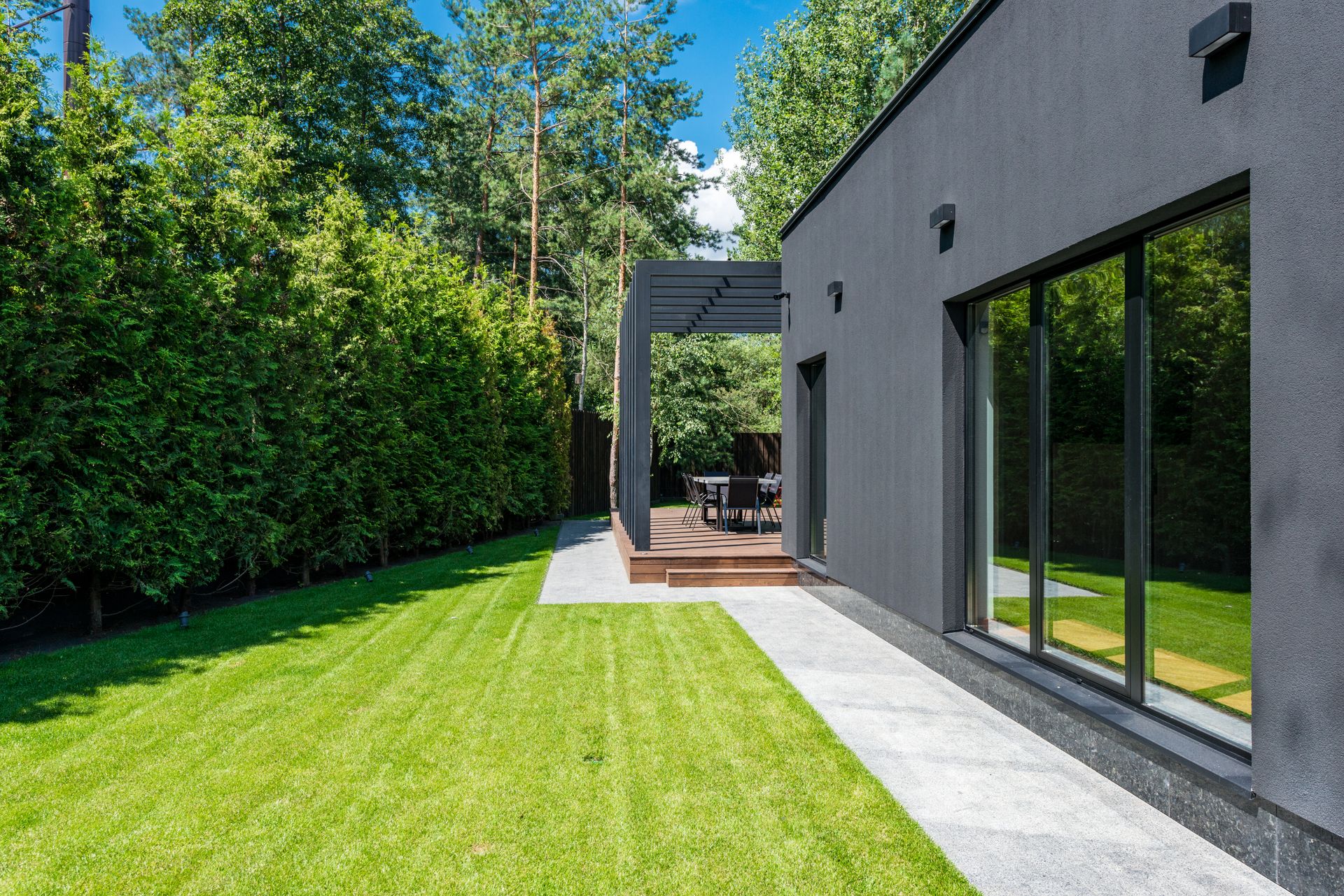 A modern home with a freshly mowed lawn and clipped hedges